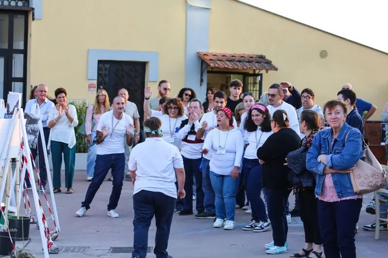 I ragazzi del laboratorio in maglia bianca festeggiano con il pubblico
